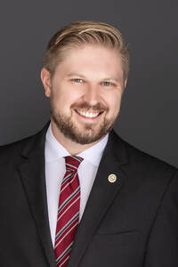 Anthony Angelini in a dark suit and striped tie